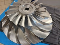 a stainless steel propeller on a blue table