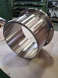 a stainless steel flange on a table in a workshop