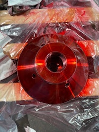 a red metal plate is sitting in a plastic bag